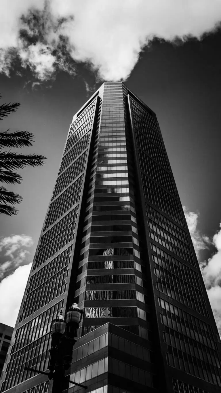 Striking black and white photo of an urban skyscraper against a cloudy sky.